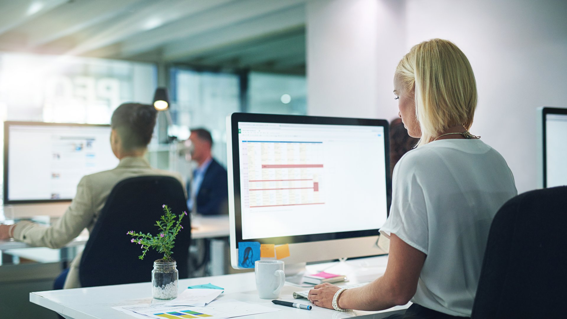 Generische Officeszene: Frau sitzt vor Bildschirm